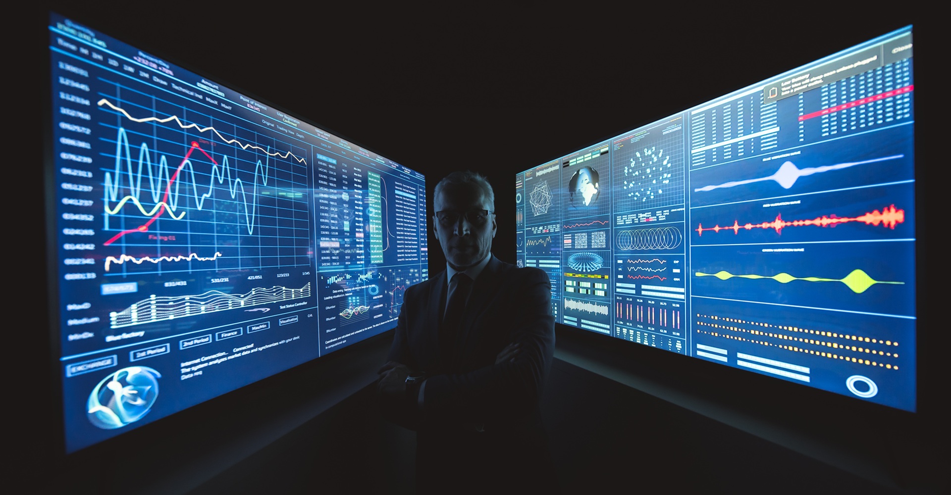 The businessman stands near the big blue screen with graphics